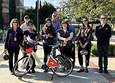Group of Bruins on campus with a Metro Bike Share bike