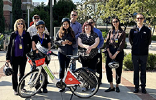 Group of Bruins on campus with a Metro Bike Share bike