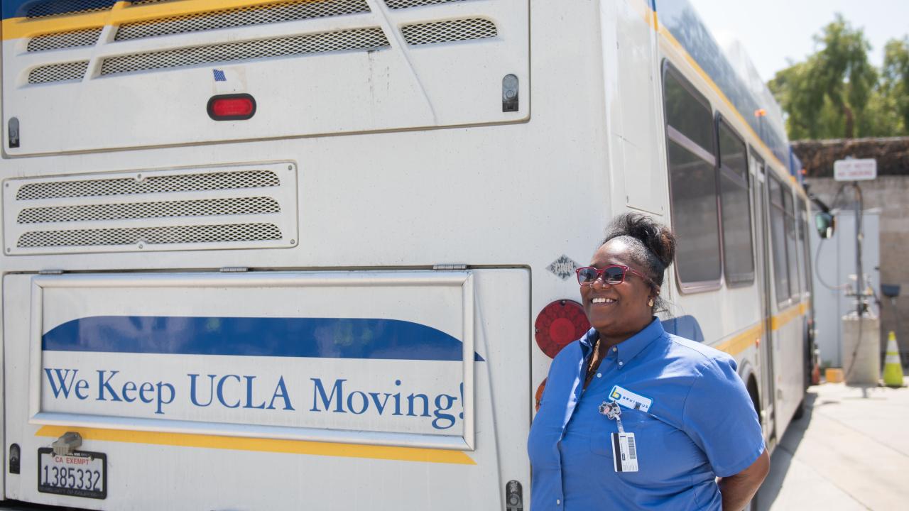 BruinBus Operator Alexis Powell stands next to a BruinBus.