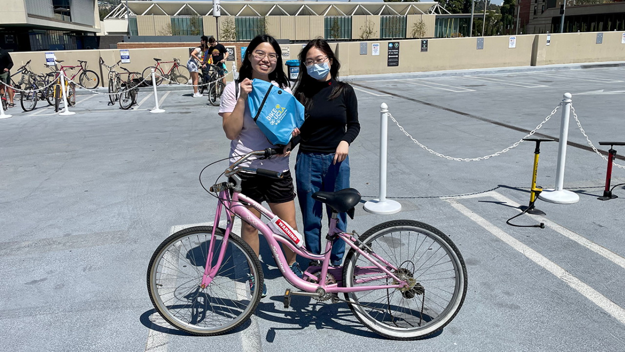 Two UCLA students with a pink bike
