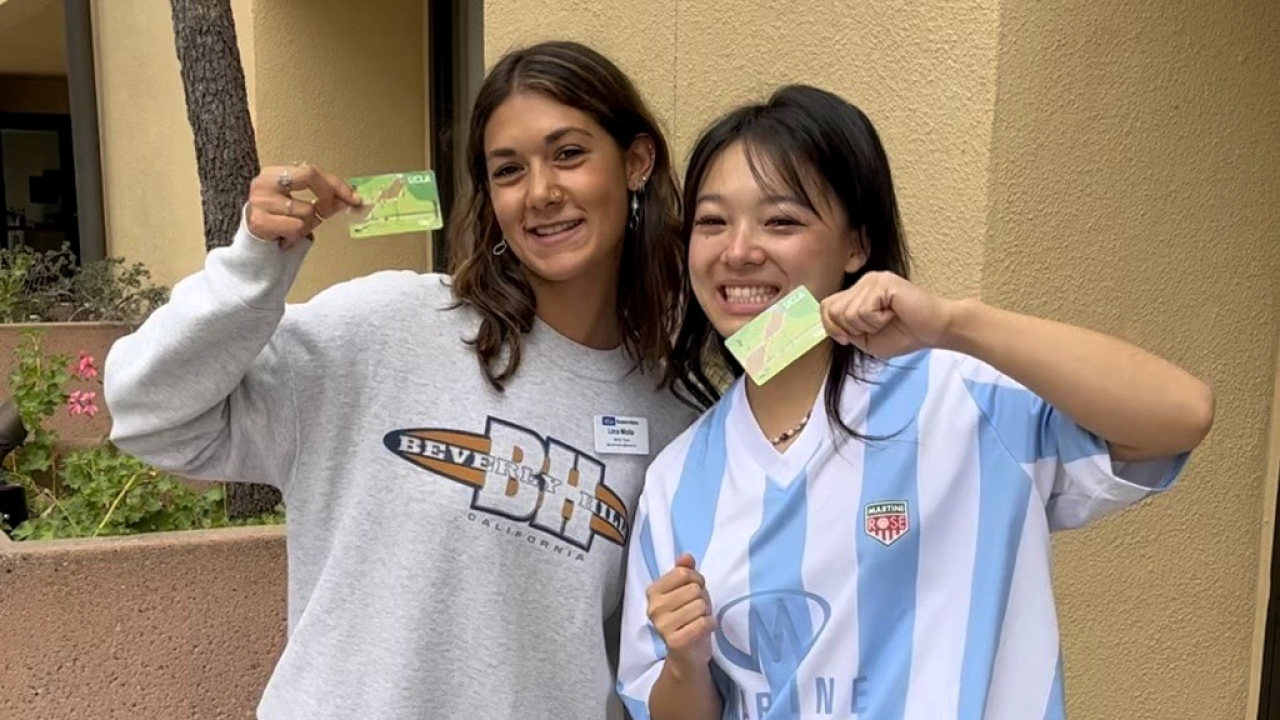 Two students holding up their TAP cards