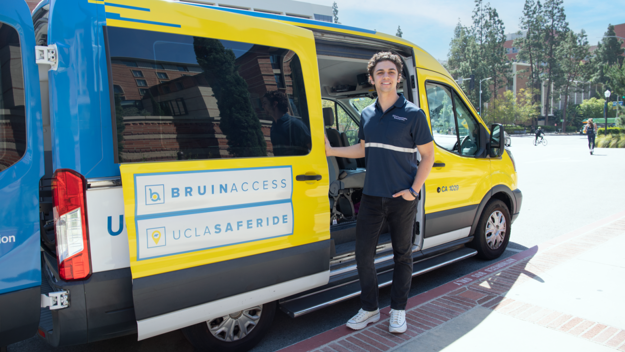 Student Driver opening the door of a BruinAccess van
