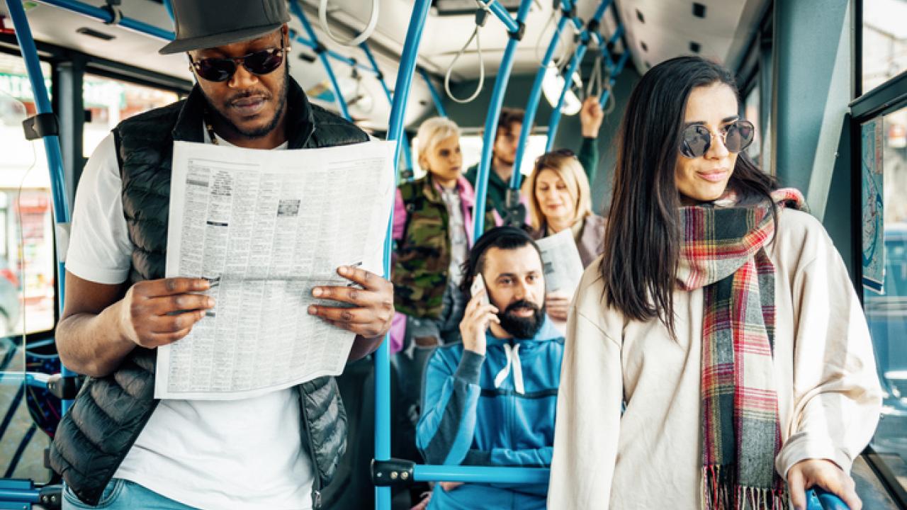 Cool people reading the paper on the bus