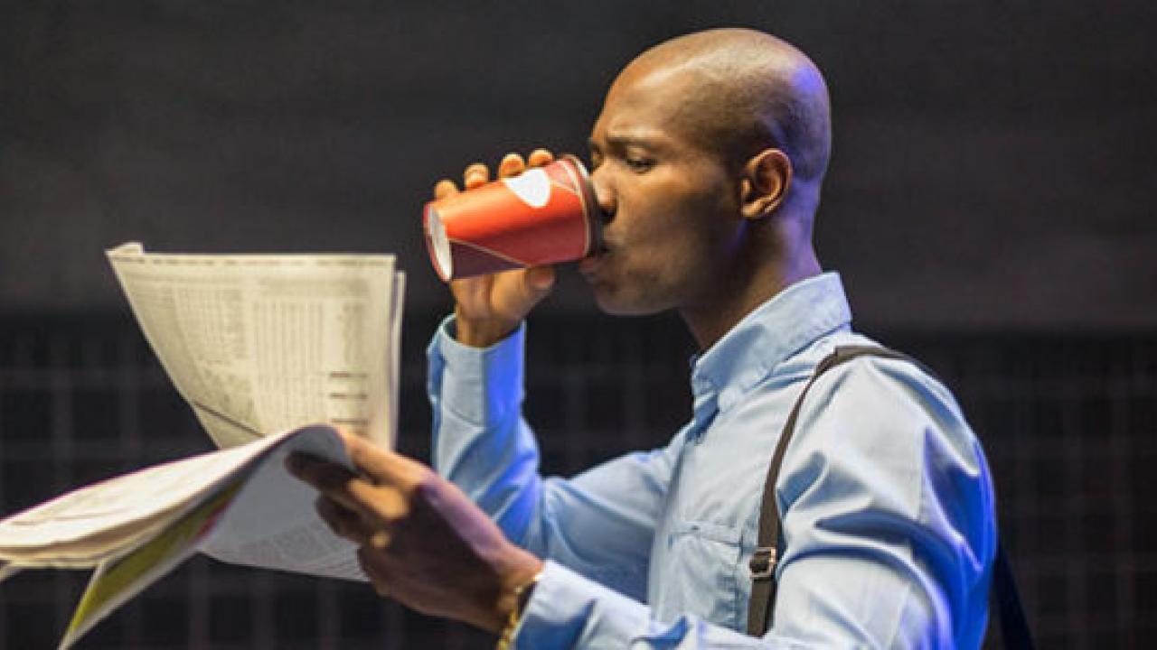 Commuting businessman reading newspaper and drinking coffee