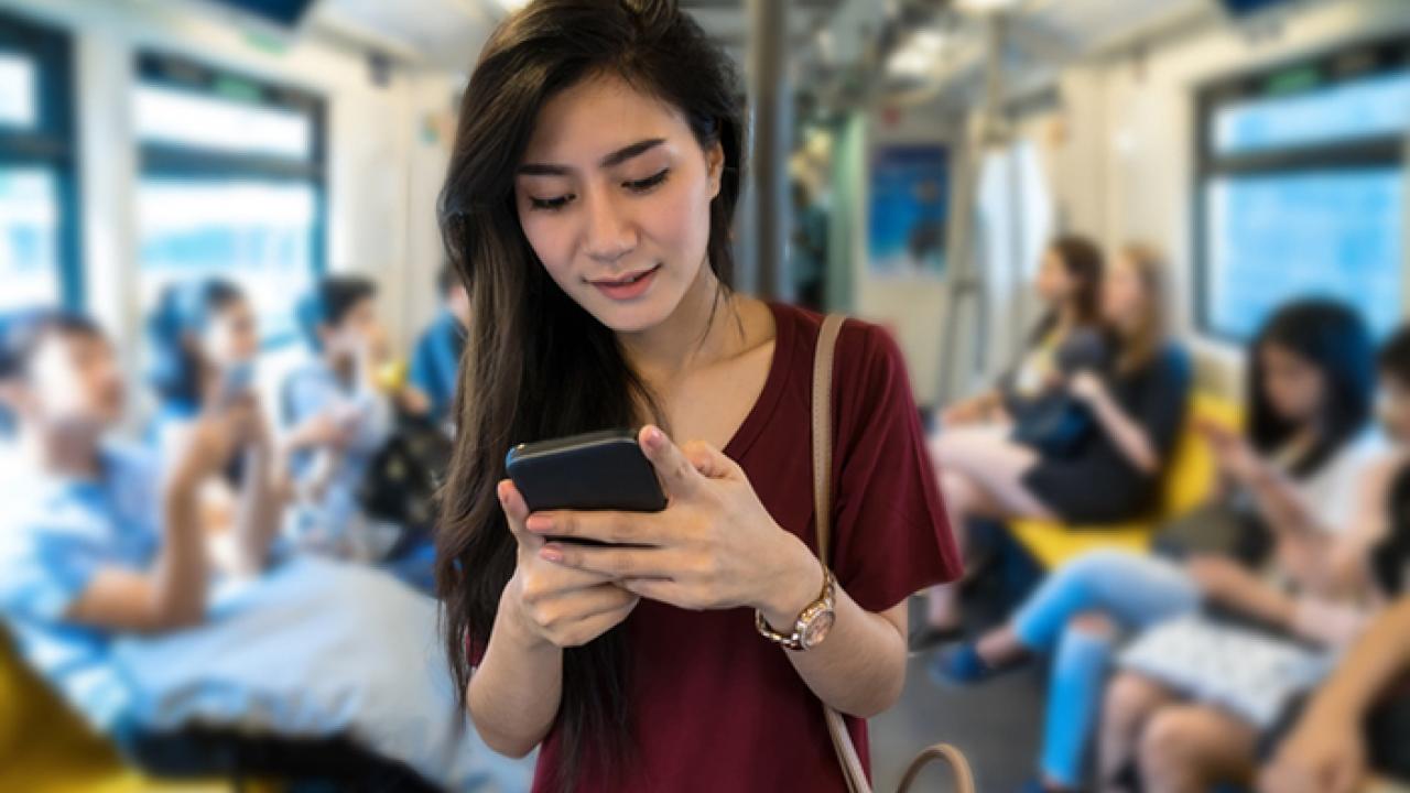 Woman on a bus looking at her phone