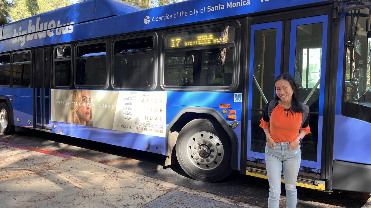UCLA grad student Ivy in front of Big Blue Bus on campus