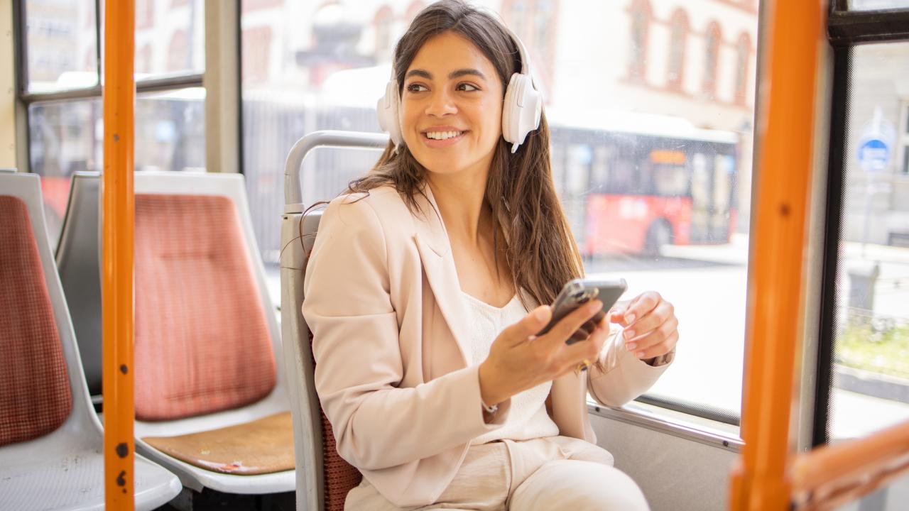 Young woman riding bus with headphones on