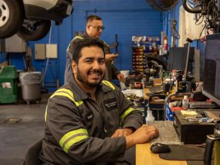 Mechanic smiling at this desk in the fleet garage.