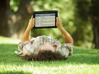 Reading a tablet on the grass