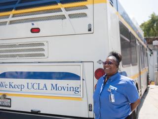 BruinBus Operator Alexis Powell stands next to a BruinBus.