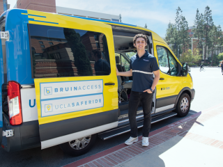 Student Driver opening the door of a BruinAccess van