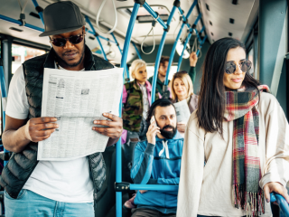 Transit riders reading the newspaper.