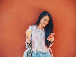 Women behind orange background reading news on phone