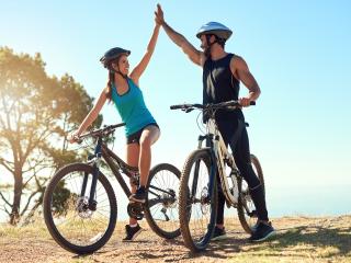 Couple High Fiving on Bikes