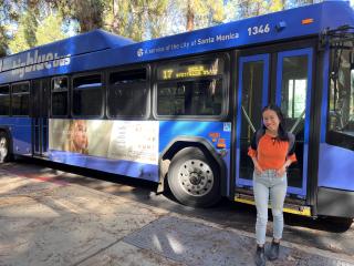 UCLA grad student Ivy in front of Big Blue Bus on campus