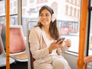 Young woman riding bus with headphones on
